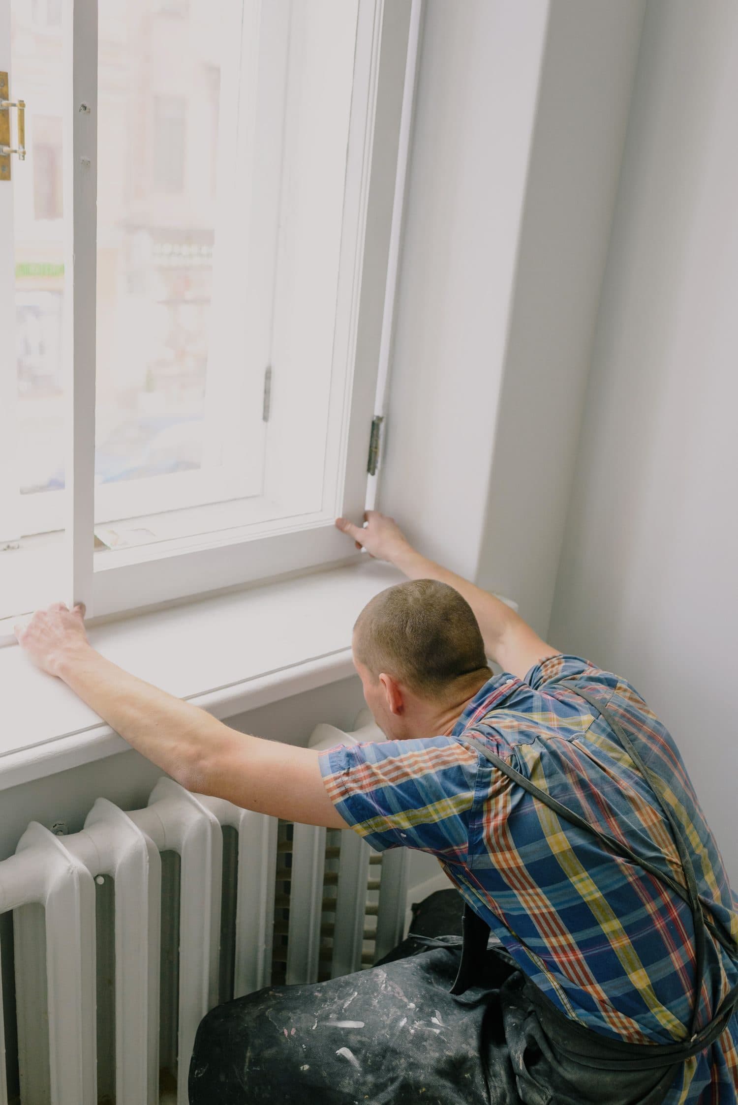 A fitter setting a window frame into an opening during a replacement